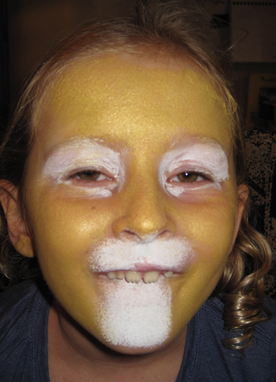 Start by applying white around the eyes and on the muzzle area (under the nose and below the mouth) with a make up sponge. Don't worry if it's a little messy, it will get covered up.