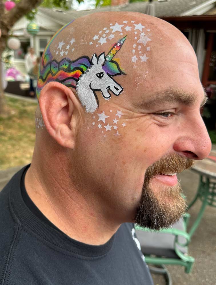 Unicorn  face paint by Auntie Stacey on bald man's head